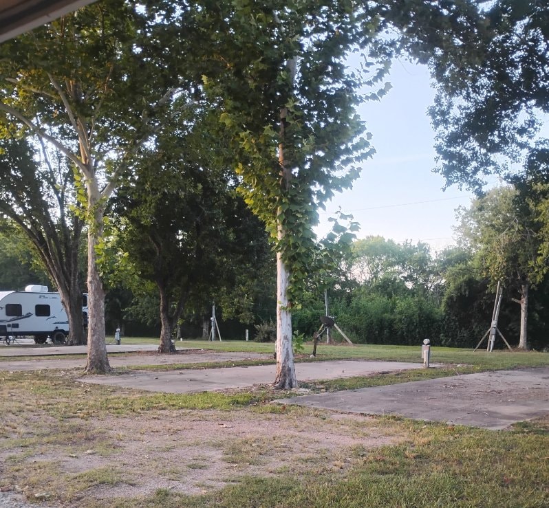 Open RV sites with concrete pads and hookup pedestals at Traveler's Paradise RV Park in Bay City, TX